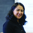 Meenakshi smiling and teaching in class wearing black sweater