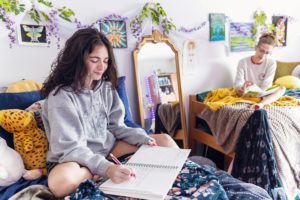 residence hall reeom with purple and green flower decor and student reading