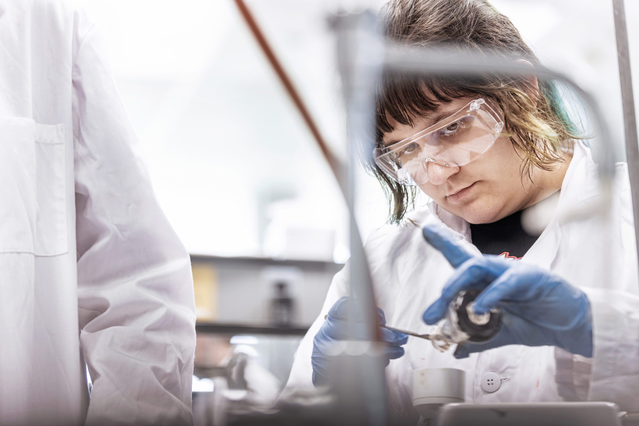 Female student in science lab wearing protective goggles
