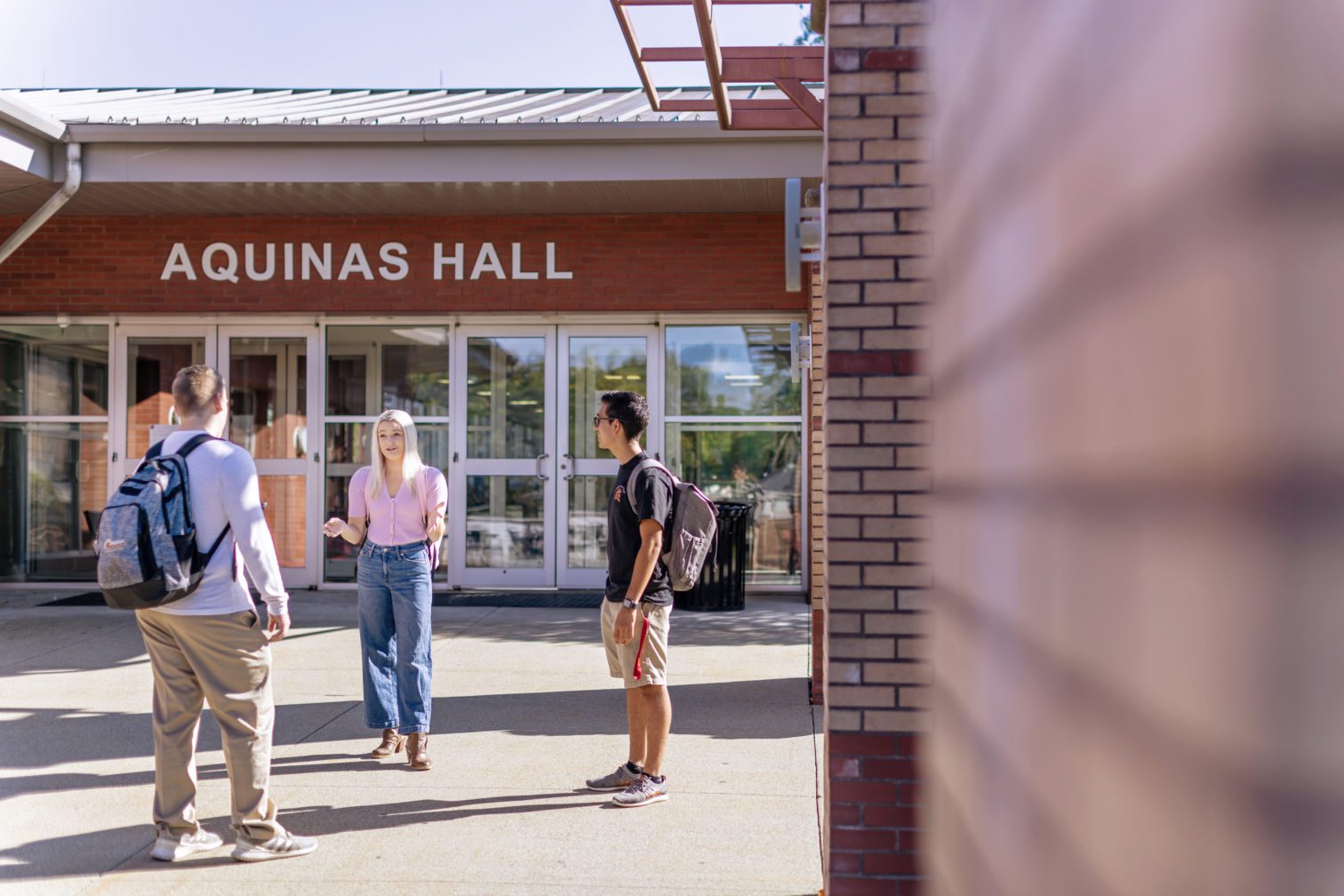 students talking in front of Aquinas Hall