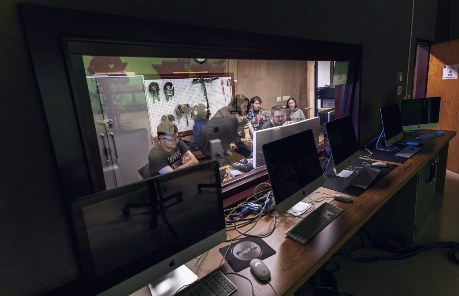 A group of students working in a sound editing room