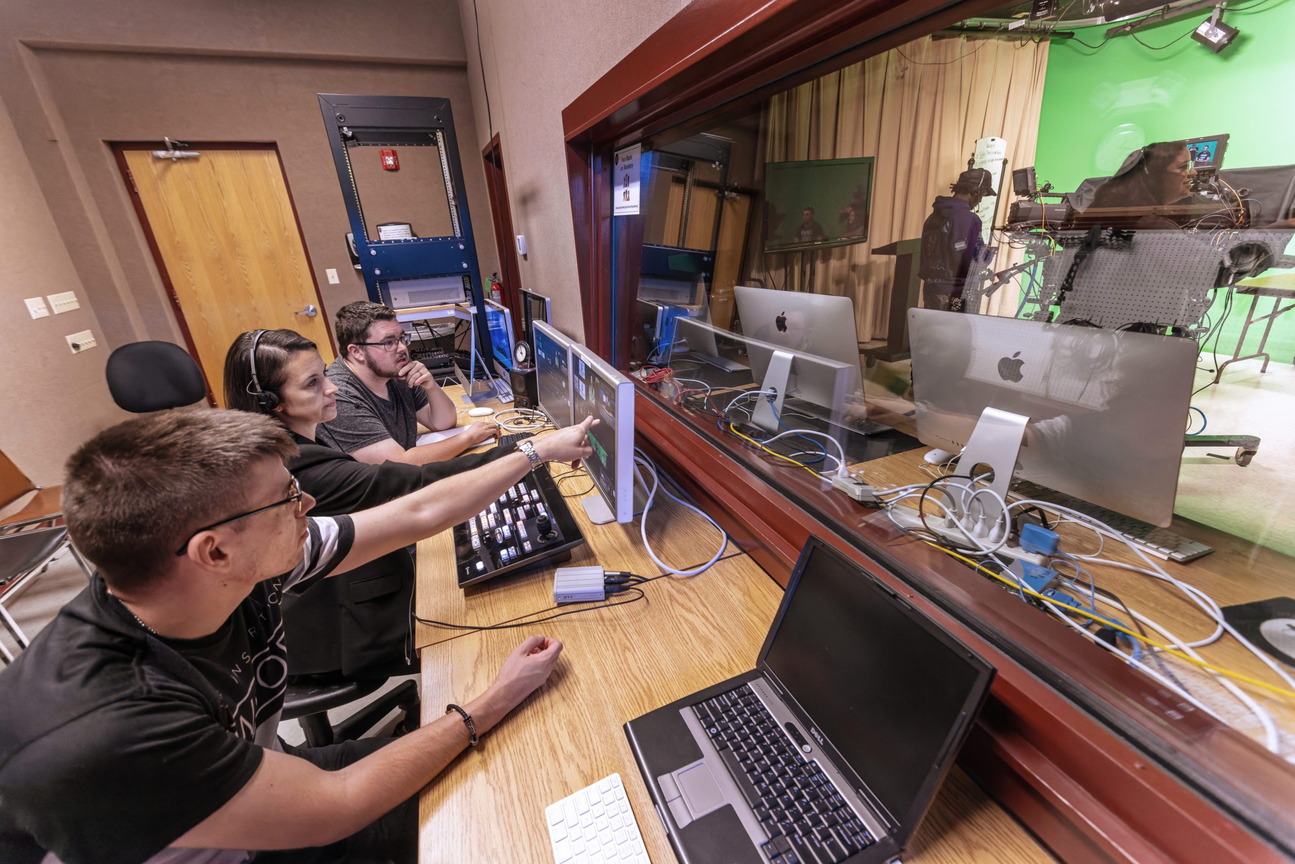 Two male students and their professor working on their computers.