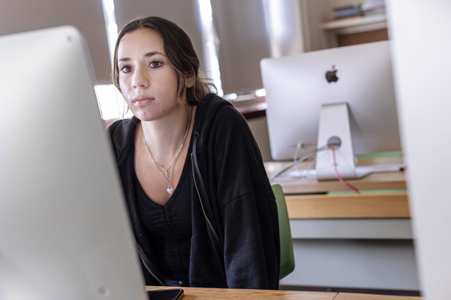 A female student writing on a computer.