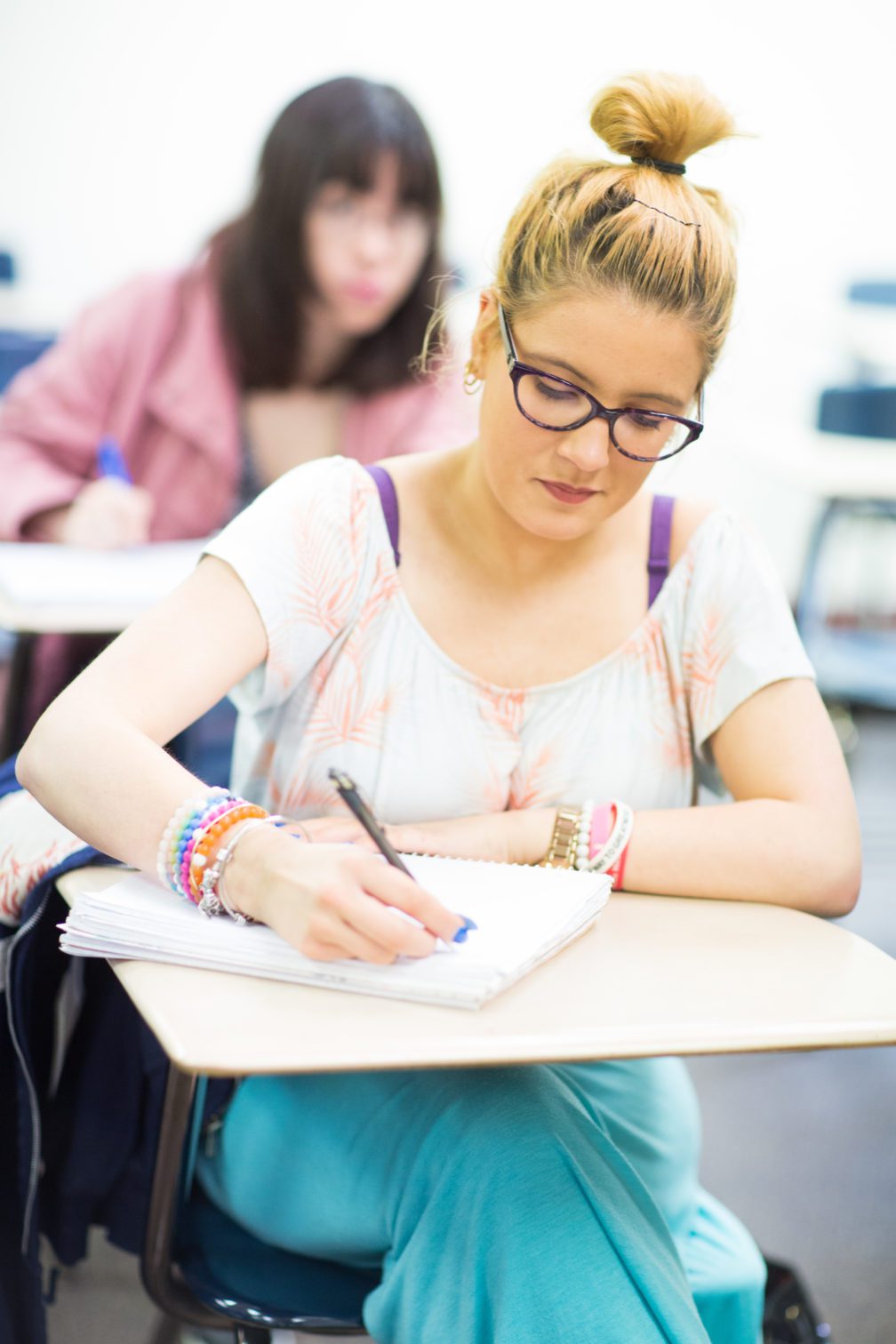 Female students writing at desk