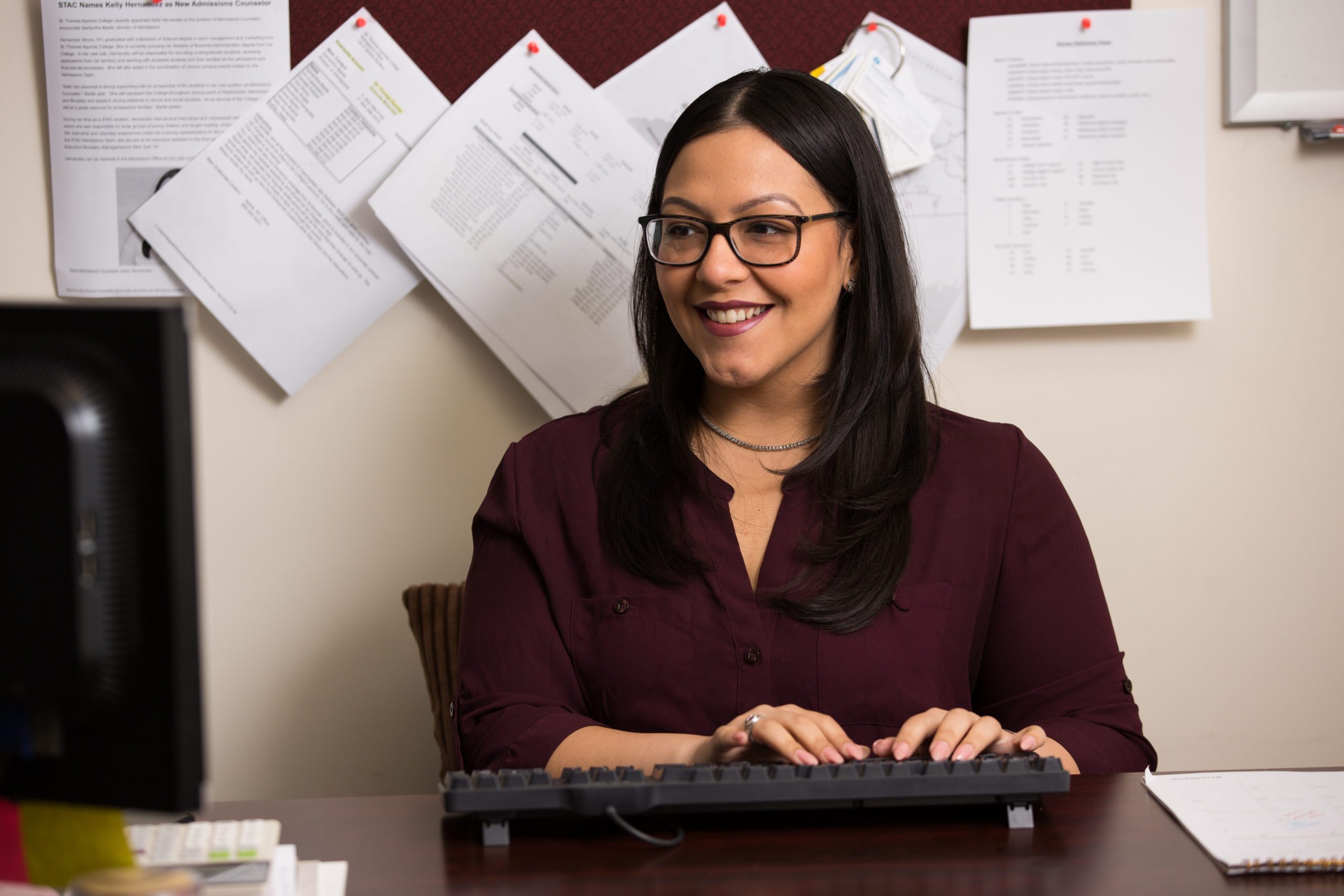 A women in an office trying on a keyboard.