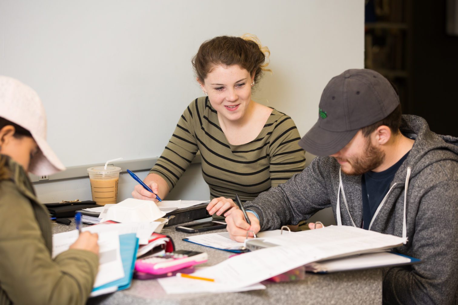 Three students studying at a table.