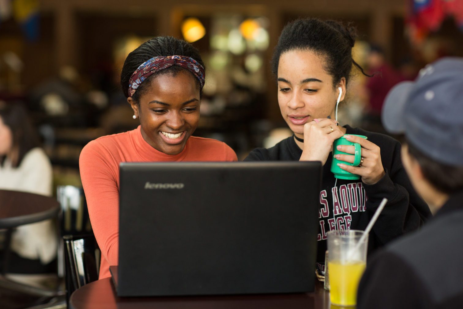 Two female students sitting at a desk working on a computer.