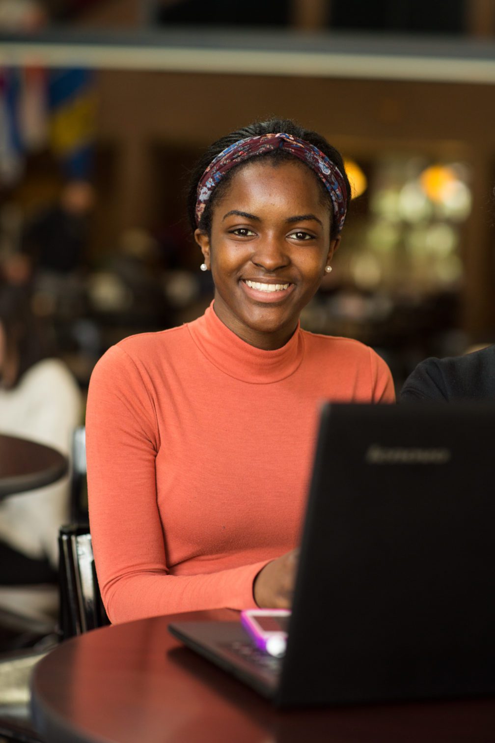 A female student sitting at a desk and working on her computer.