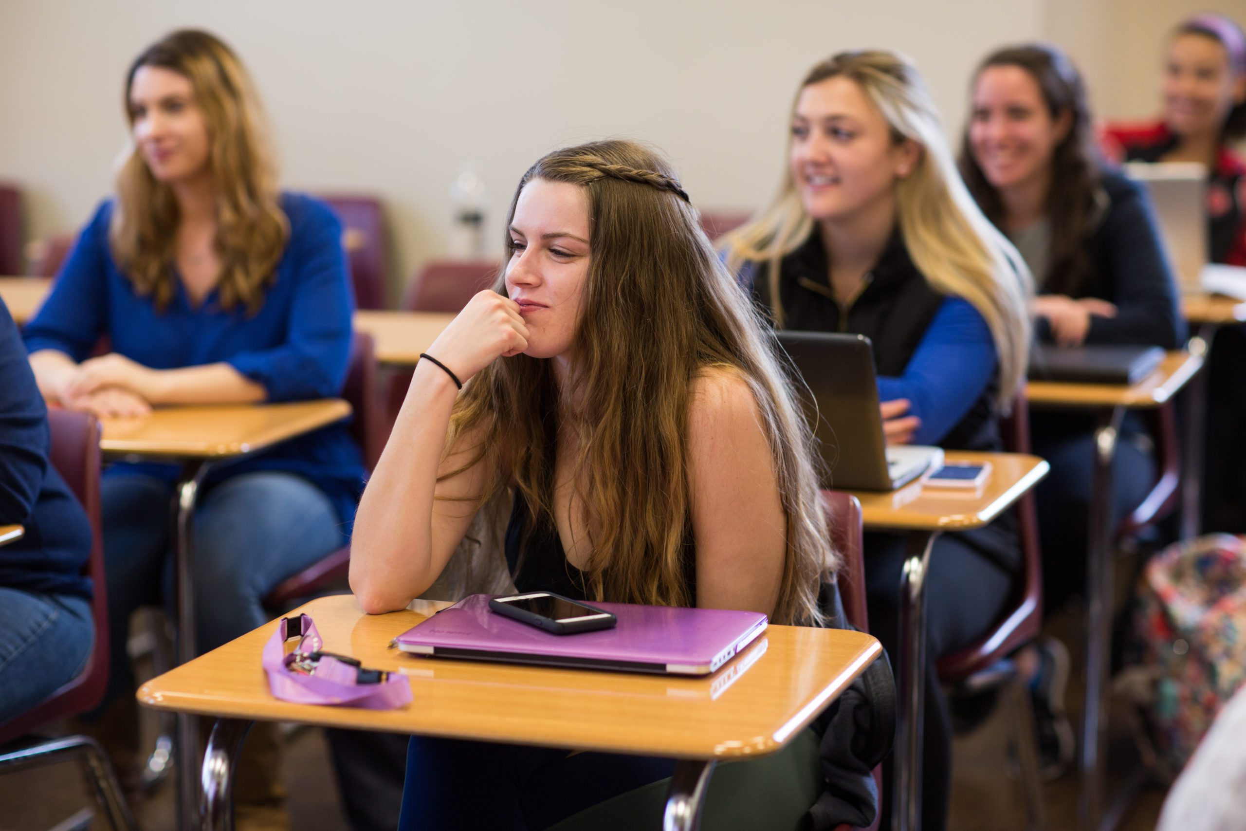 Female students in a classroom sitting at desks and learning.