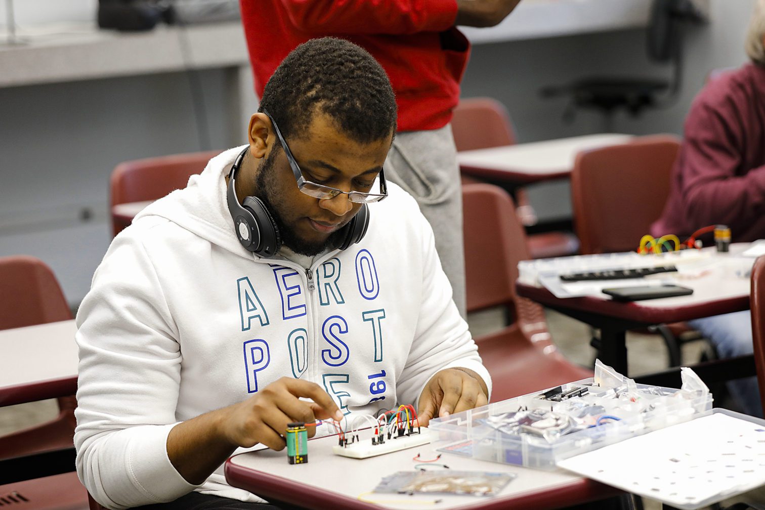 A male student working on a breadboard.