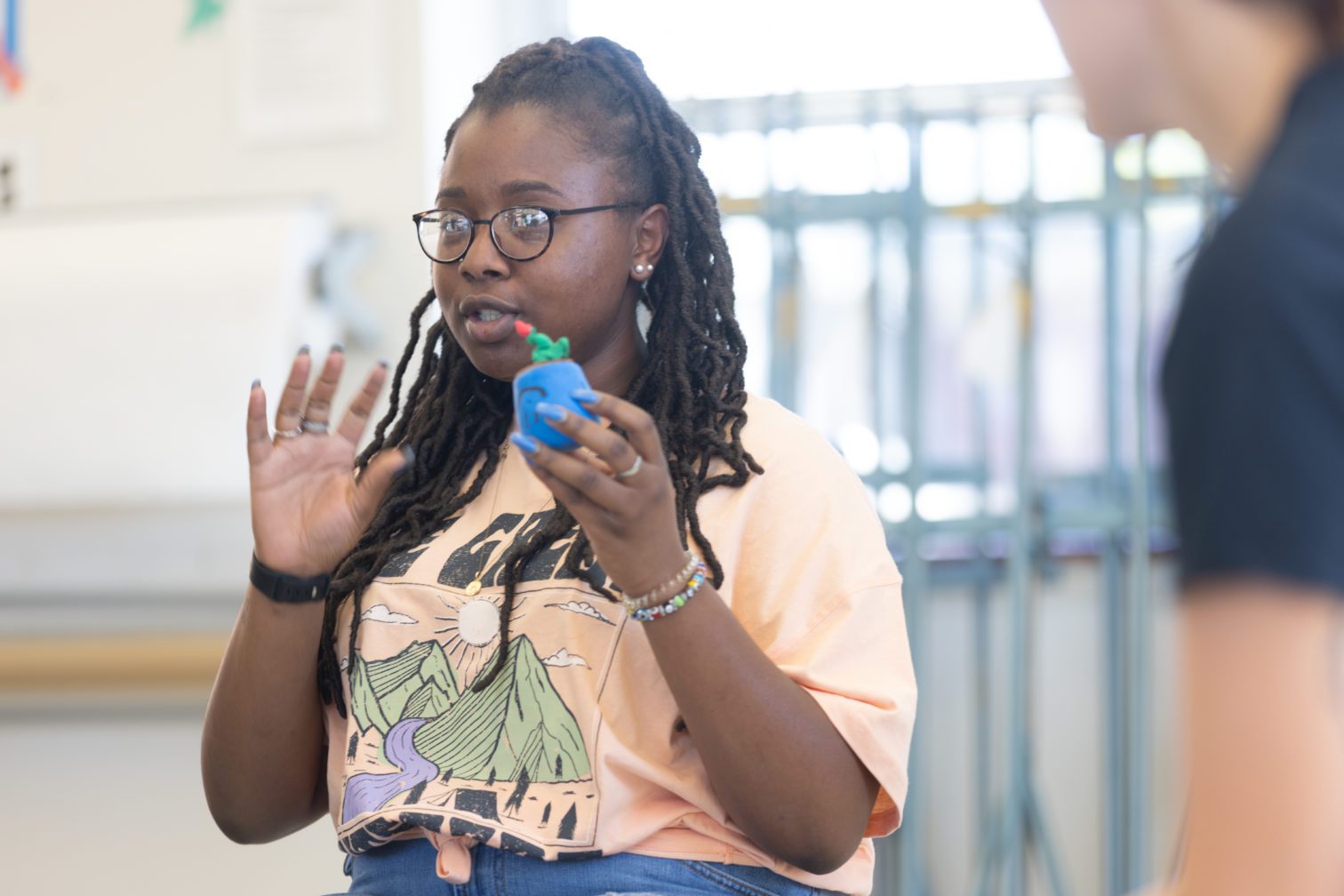 A female student holding a clay mold in Art Therapy class.