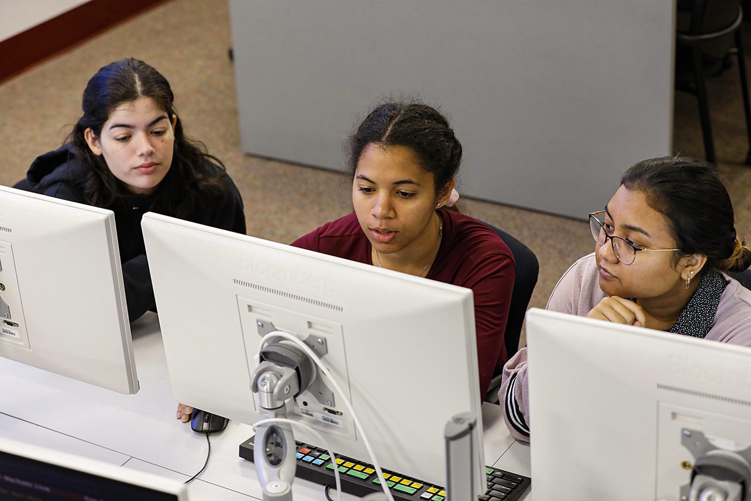 Three female students working on computers.