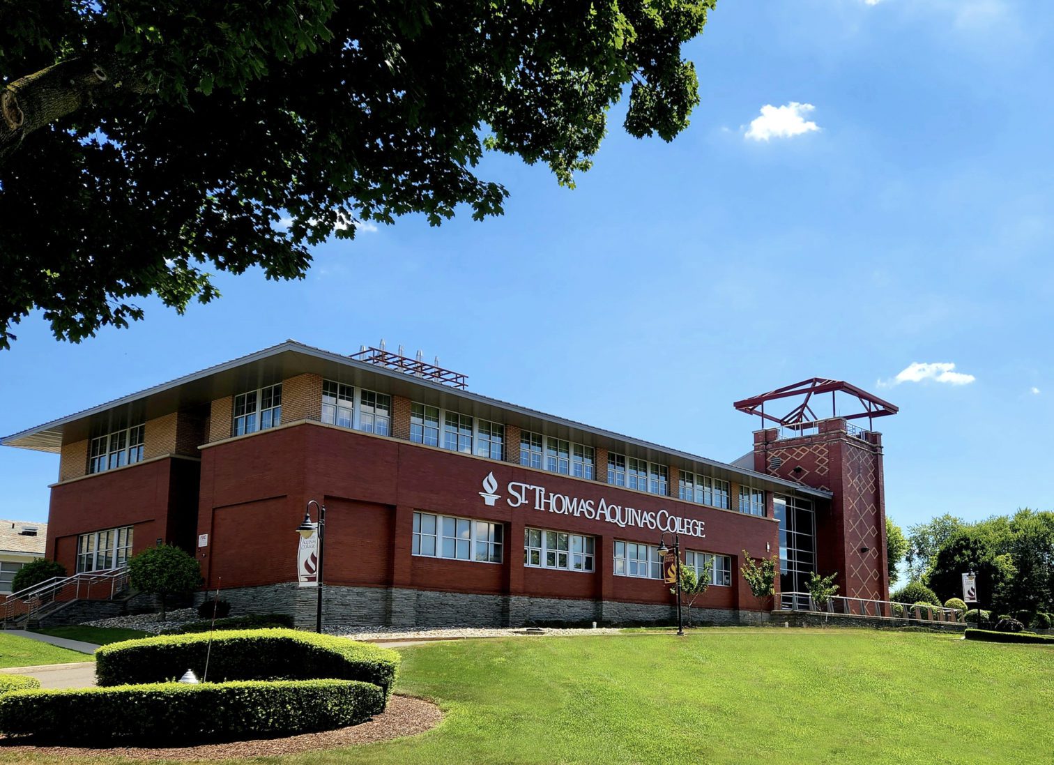 Exterior of Costello Hall building with St. Thomas Aquinas College logo