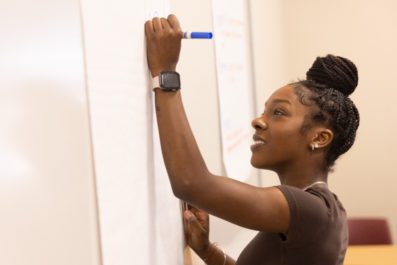 A female student writing on a white board