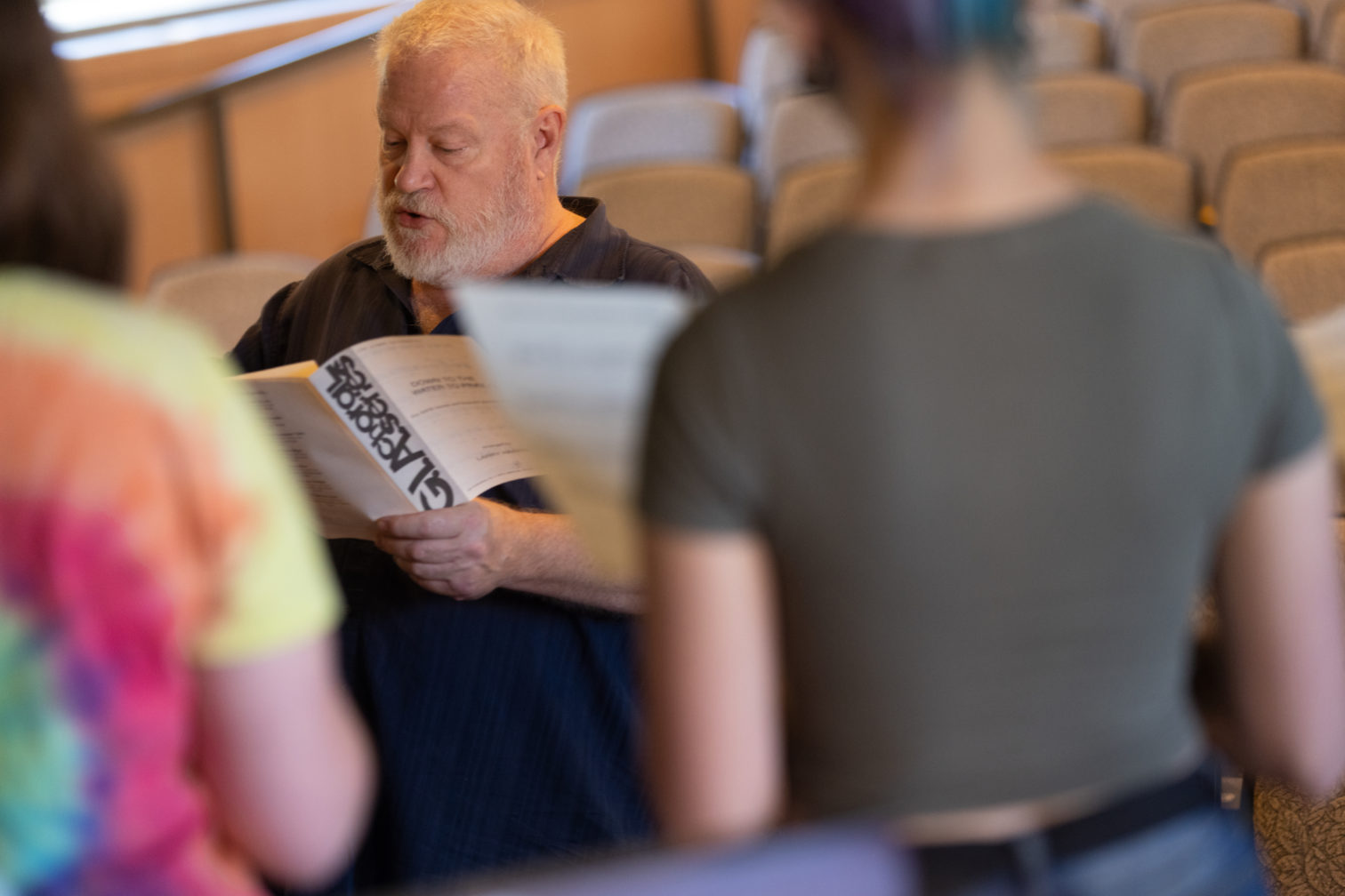 Professor Matthews and students in the Sullivan Theater reading a script.