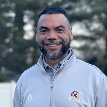 Robert Pichardo smiling outside wearing STAC gray athletics sweatshirt