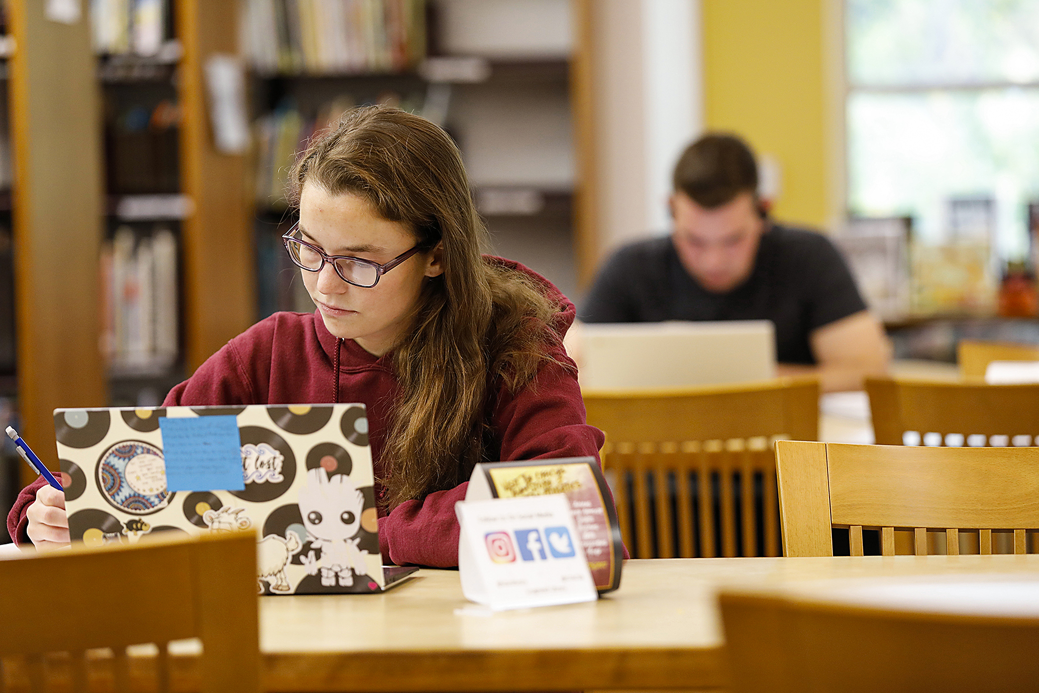 Students sitting at desks and studying in the library