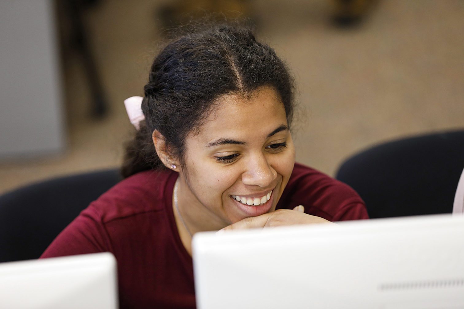 A female student sitting at a desk in the classroom.