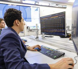 Two male students sitting at desks in the Bloomberg lab working on computers.