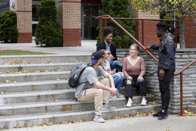 Students sitting on the stairs outside.