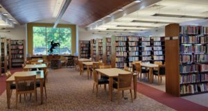 Library with book stacks and desks and window in background