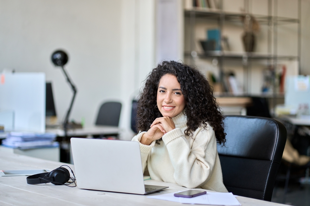 A female student sitting at a desk with a laptop in front of her