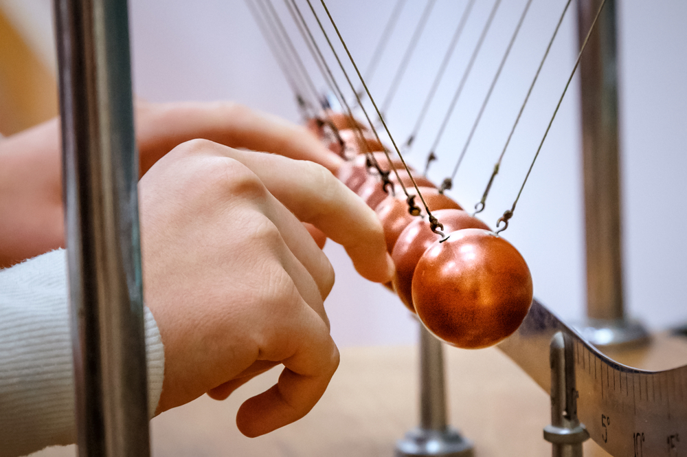 A student touching Newton Cradle