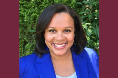 Shannon Hargrove smiling wearing blue blazer with green bush in background
