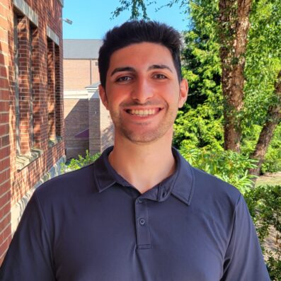 Zach Faddah smiling outside wearing navy blue tshirt