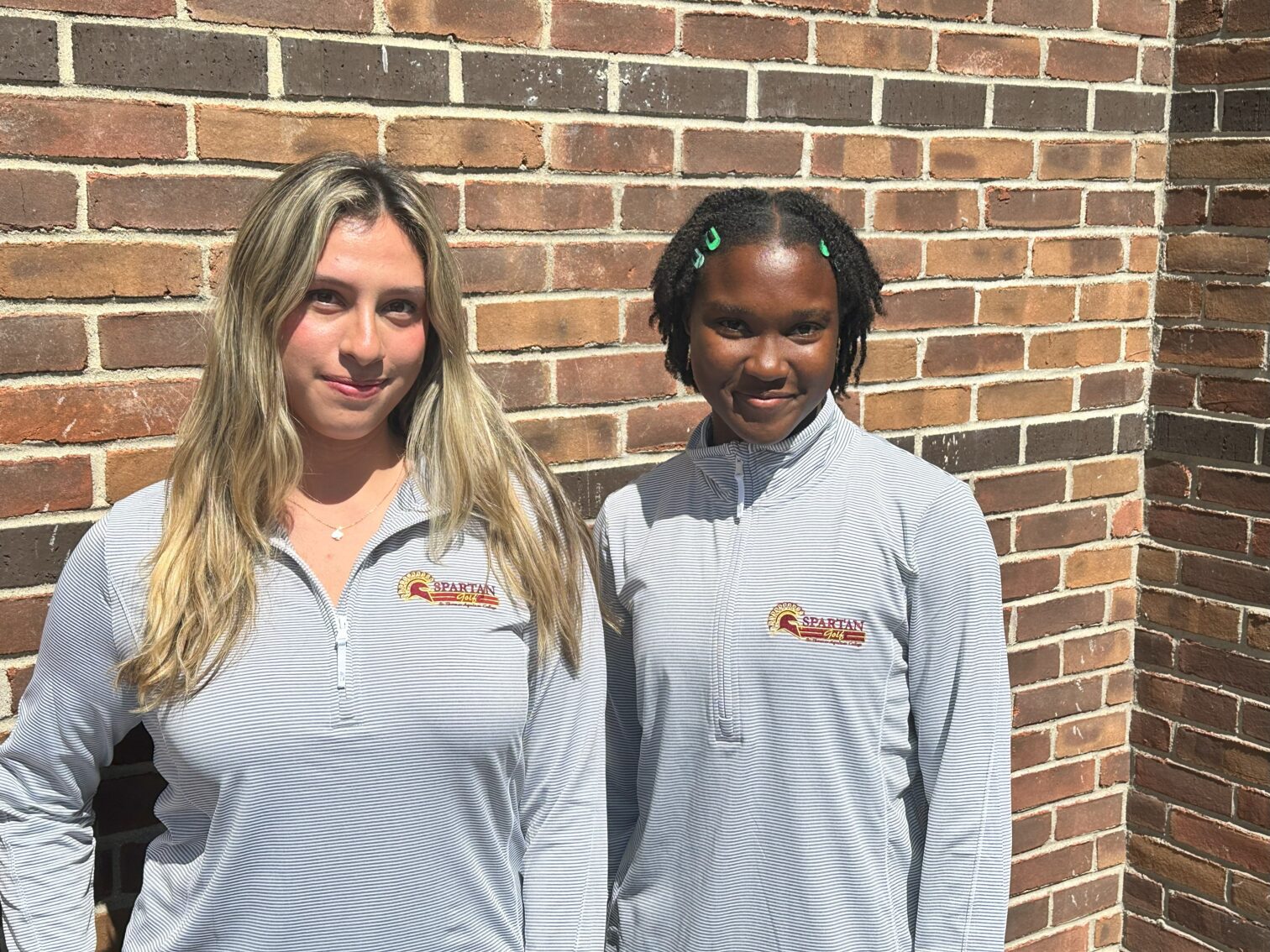 Two female students wearing Quarter Zip Pullovers