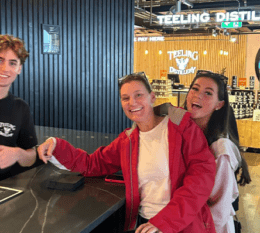 Devin smiling with two family members while at Distillery