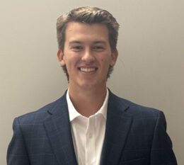 Will smiling wearing navy suit jacket