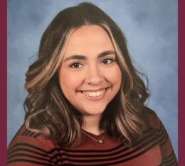 Lauren smiling wearing sweater and necklace with hair down