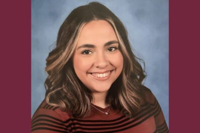 Lauren smiling wearing sweater and necklace with hair down